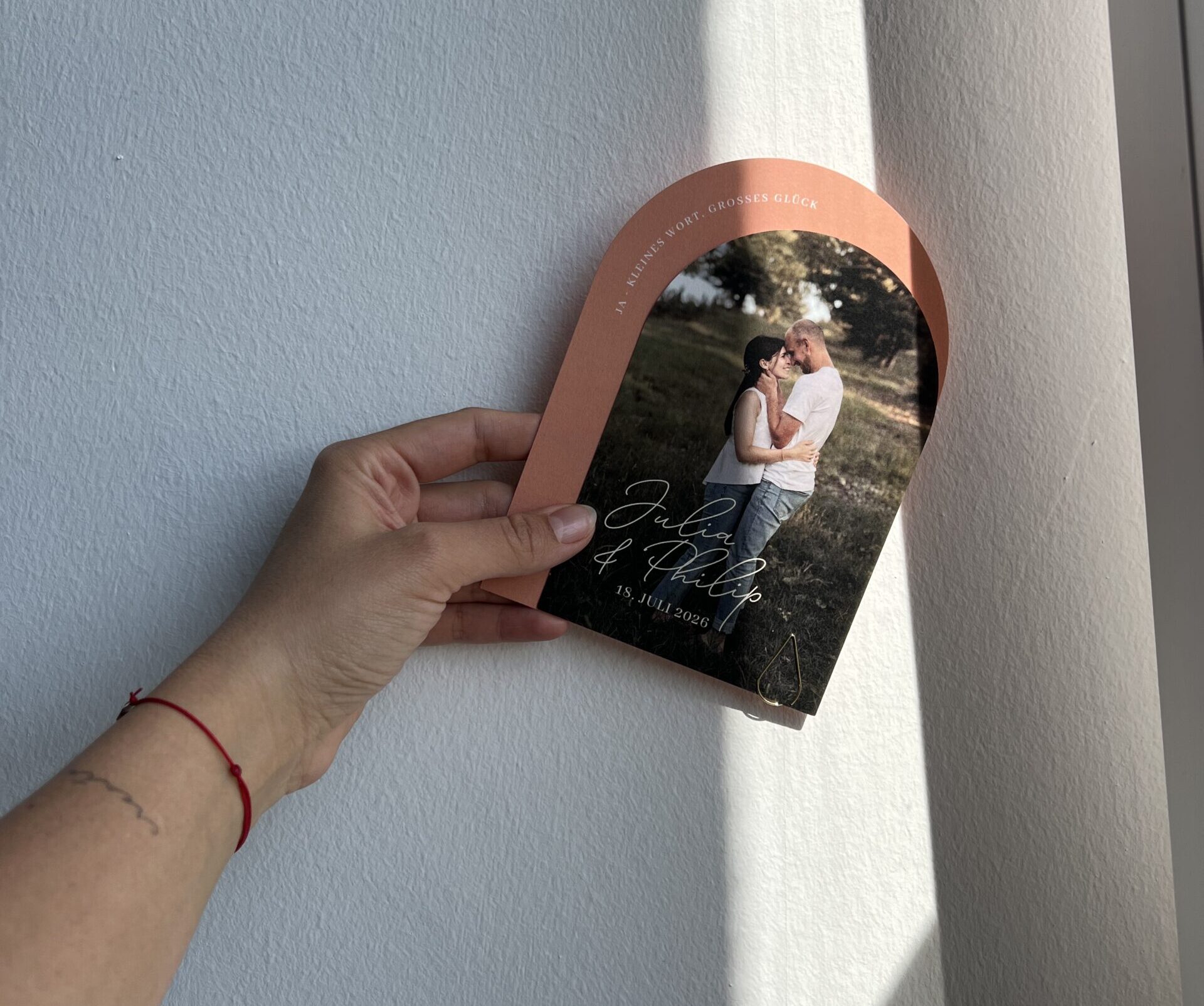 Eine Hand hält eine Hochzeitseinladung